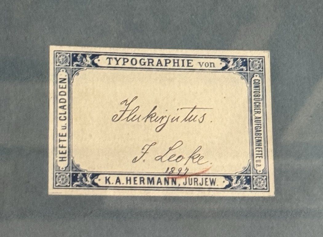 Blue exercise-book cover with a printed label, handwritten “Ilukirjutus. J. Leoke 1897”.