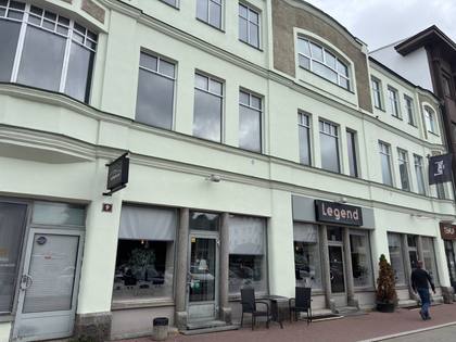 Color photo, October 2026: the pale green Art Nouveau façade of Tartu 9 with shop windows.